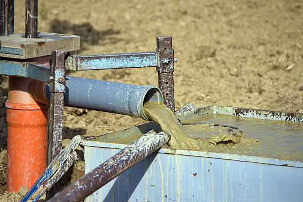 Bomba de achique extrayendo agua con barro de un pozo durante limpieza profesional