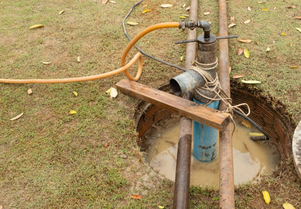 Pozo abierto con agua turbia y barro siendo vaciado con bomba sumergible